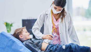 Picture of little boy having ultrasound examination by pediatrician