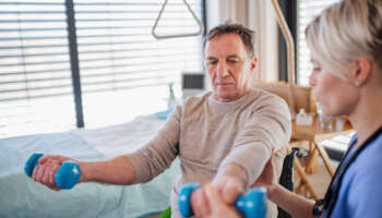 A healthcare worker and senior patient in hospital, physiotherapy concept.