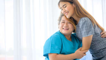 Happy patient is holding caregiver for a hand while spending time together